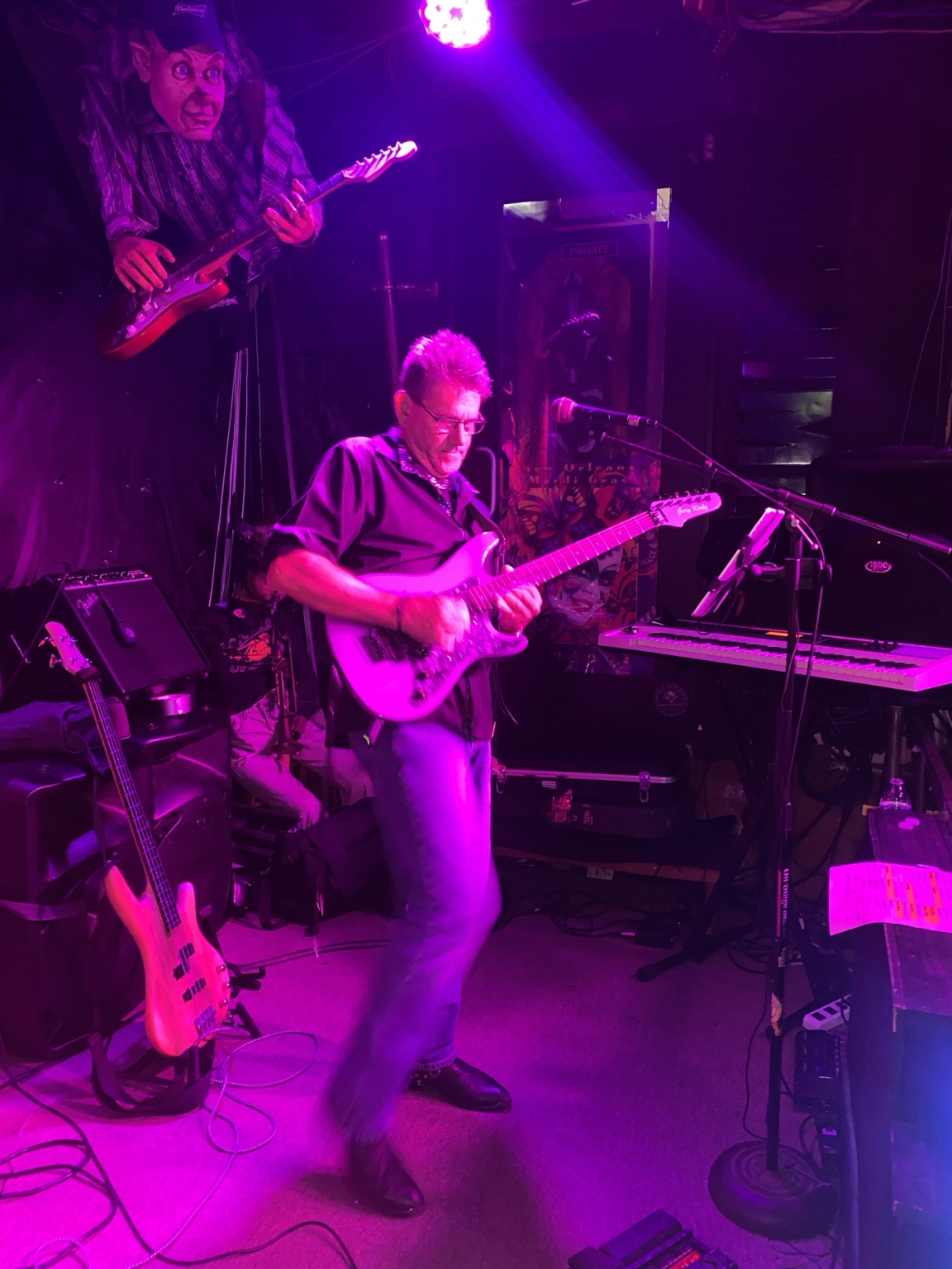 Guitarist playing on stage under purple lights