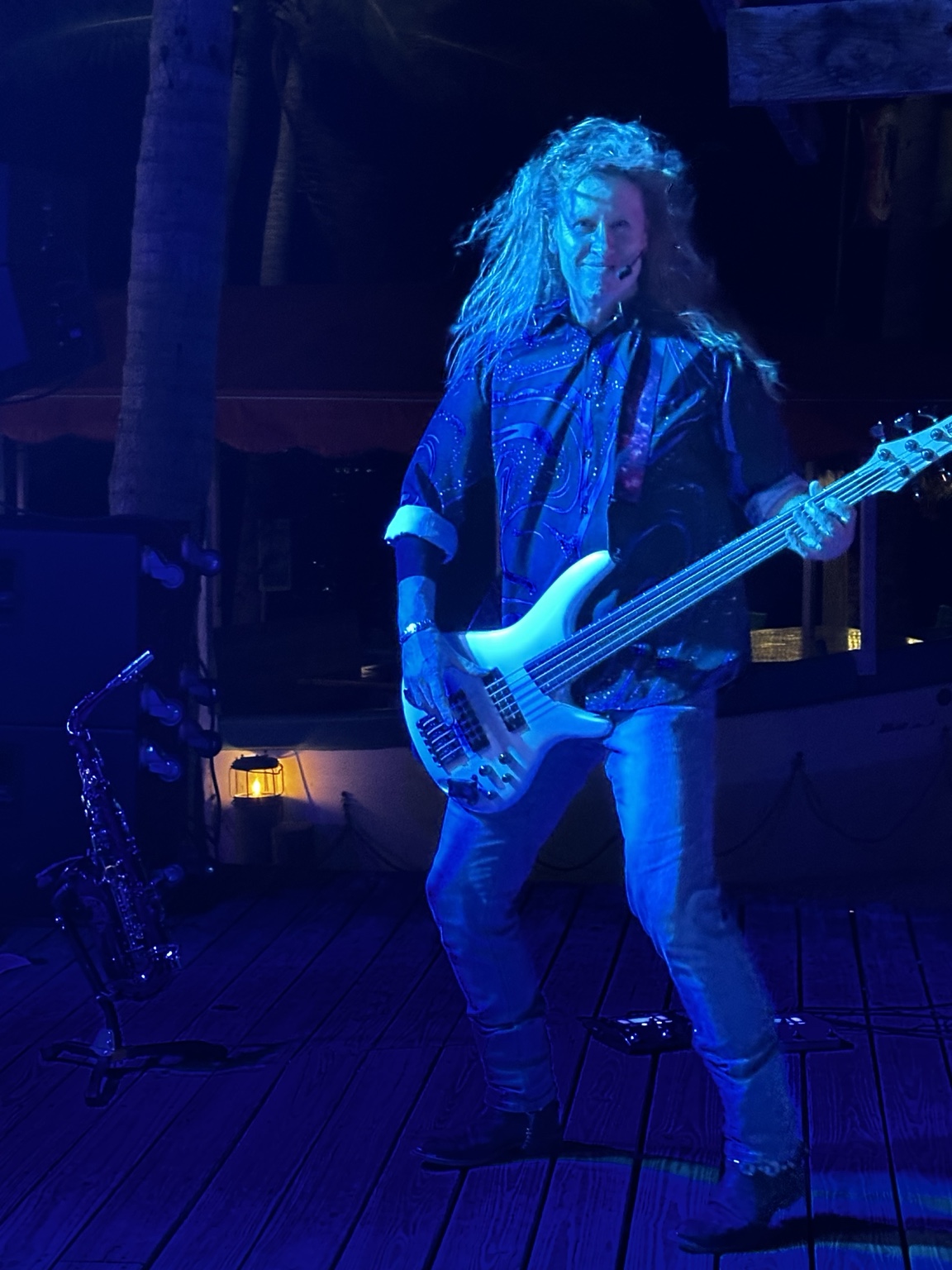 Bassist performing under blue stage lights