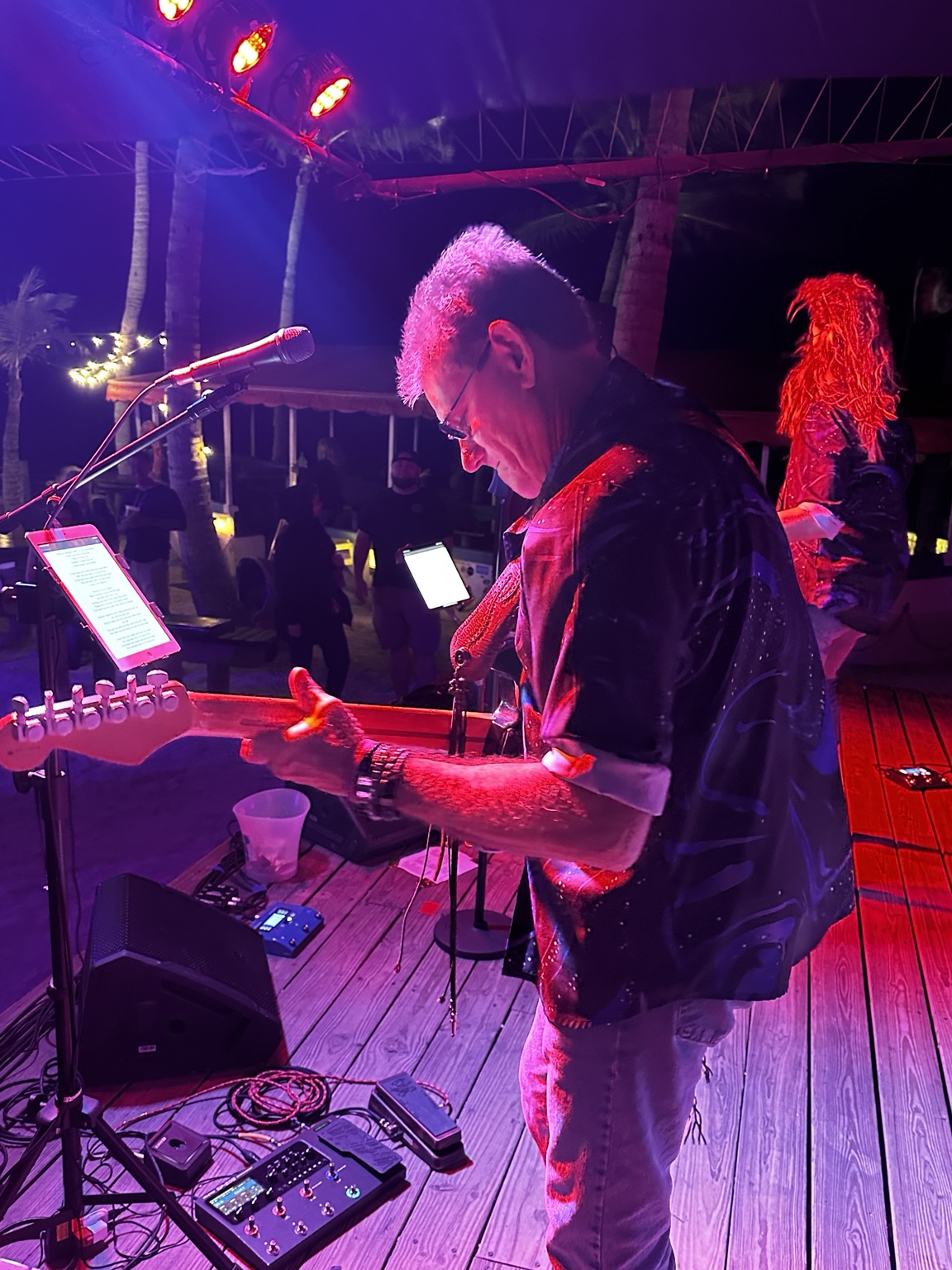 Guitarist performing under pink and purple stage lights
